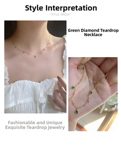Detail of vintage gold-plated chain featuring emerald-green teardrop and square gemstones