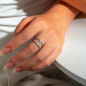Detail of silver twisted rope texture and interlocking geometric link on unisex steel ring