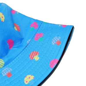 Detailed view of stitching and colorful mushroom print on a blue sun bucket hat