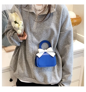 Blue mini crossbody bag featuring a white bow detail and silver ball chain strap