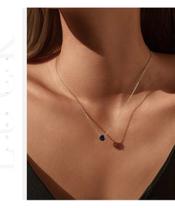 Detail of royal blue rose cut gem pendant on S925 silver chain worn by a model