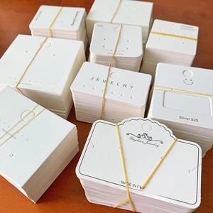 Bulk packs of various white jewelry display cards for earrings and necklaces