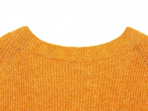 Macro shot of orange knit sweater neckline showing thick round neck texture and soft fabric