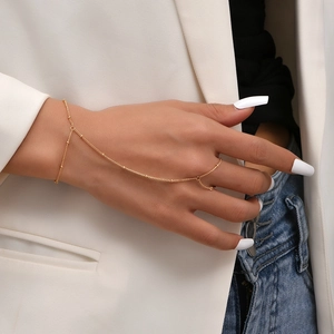 Detailed view of a gold bracelet ring combo with butterfly sequins and fine beaded chain