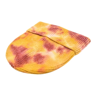 Detail view of tie-dye knit beanie showing red and yellow patterns and ribbed texture