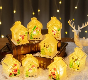 Close-up of glowing LED Christmas house miniatures with Santa and Reindeer designs