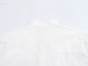 Close-up of white romantic blouse back view with delicate lace stitching on cuffs and collar