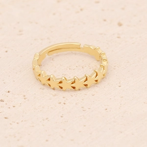 Adjustable gold plated star ring with micro-set cubic zirconia on beige rock background
