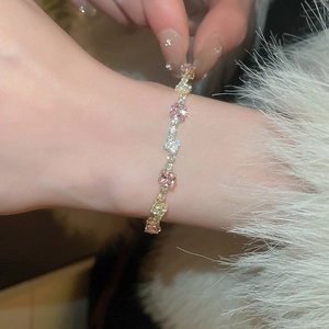 Close-up of pink and clear square-cut zircon bracelet on wrist with soft texture
