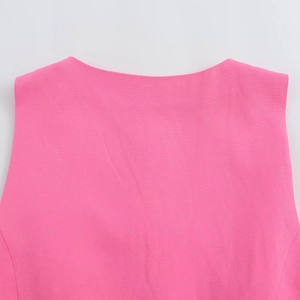 Gros plan détaillé du col rond rose et de la texture tissée de haute qualité du gilet