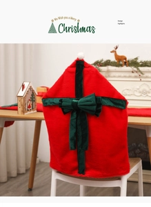 Detail of red plush Christmas chair cover featuring a dark green velvet bow and white pompom
