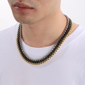 Vue rapprochée de colliers à triple chaîne box en acier inoxydable doré argent et noir