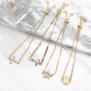 Detail of adjustable gold-plated cross bracelets featuring colorful zircon stones