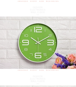 Detail of green wall clock with 3D white numerals on white brick wall background