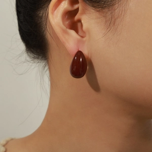 Elegant hollow water drop earrings in dark amber glaze with a luxury minimalist style