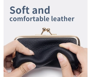 Close-up of soft black genuine leather texture and gold metal clasp closure of the purse