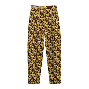 Pantaloni a vita alta con motivi geometrici gialli e marroni su uno sfondo bianco