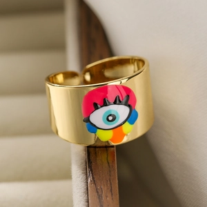 Detailed close-up of an 18K gold-plated evil eye ring resting on a luxury jewelry box