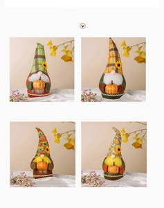 Detail of four fall gnomes with sunflower hats and tiny pumpkins for holiday decoration