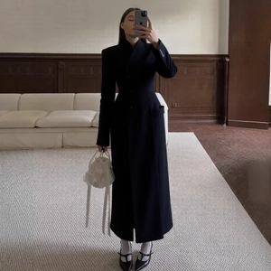 Élégant trench-coat noir long et ajusté pour femme avec taille cintrée et manches longues