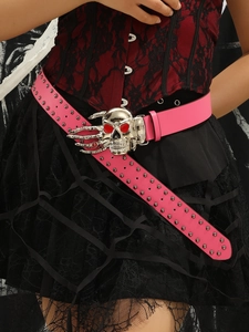 Detail of pink punk leather belt with silver rivets and 3D skull buckle with red gems