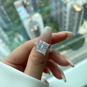 Detail shot of princess cut cubic zirconia ring worn on hand with city background