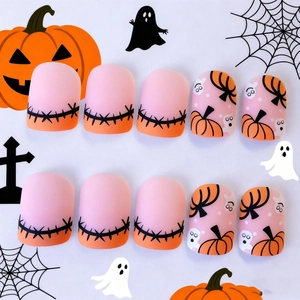 Halloween press-on nails with pumpkin and ghost motifs on matte pink gradient