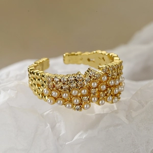 Detail of gold-plated ring with pearls and pavé cubic zirconia in honeycomb setting