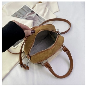 Detail view of the brown and beige plush handbag featuring a herringbone fabric lining