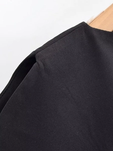 Détail de la texture du tissu et des coutures d'épaule sur ce haut noir élégant