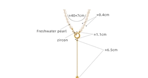 Macro shot showing dimensions of gold pearl necklace with zircon pendant and tassel