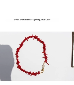 Detail view of irregular red coral stone necklace with freshwater pearl and gold lobster clasp