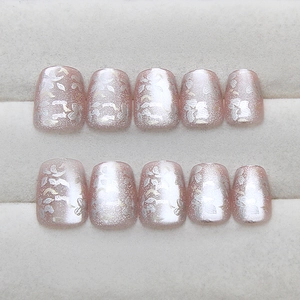 Cat eye cat-eye press-on nails with pink glitter finish and delicate white flower patterns