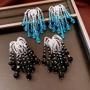Vintage silver tassel earrings with blue and black glass beads in a luxury jewelry tray