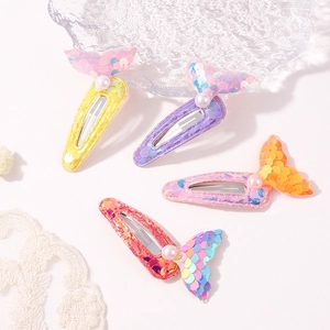 Close-up of mermaid tail hair clips with colorful sequins and white pearl details