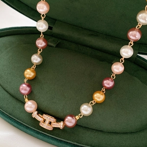 Close-up of multicolor pearl necklace with a luxury zircon paved gold H-shaped clasp