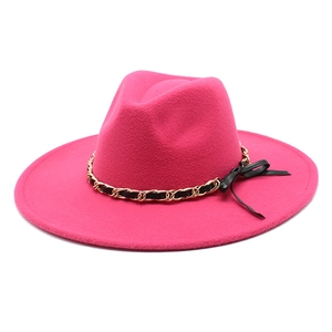 Detail of rose red fedora hat with gold chain ribbon and black bow decoration