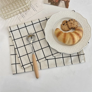 Detail of black and white checkered linen placemats with realistic woven texture details