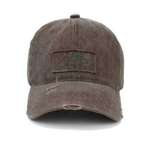 Close-up of brown washed cotton baseball cap with mountain patch and distressed details