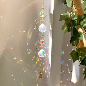 Detailed suncatcher with gold metal frames and crystal prisms creating colorful light spots