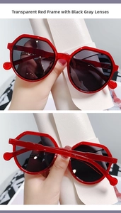 Detail view of transparent red polygon sunglasses frame with dark grey tinted lenses