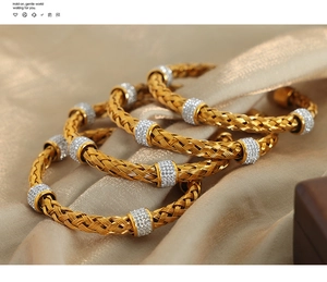 Detailed macro of gold-plated woven bangle set with micro-inlaid sparkling rhinestones