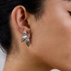 Elegant silver stainless steel leaf-shaped earring worn on a model with metallic shine