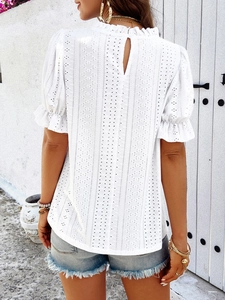 Detailed back view of white eyelet embroidery top with ruffle trim and teardrop button