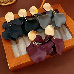 Detailed close-up of matte resin flower earrings in navy blue, burgundy, and grey