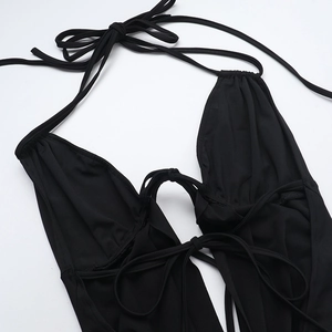 Close-up detail of black deep V-neck bodysuit with criss-cross lace-up straps