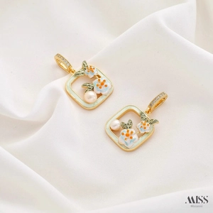 Detail of square gold pendant with enamel floral patterns and natural pearl inlay