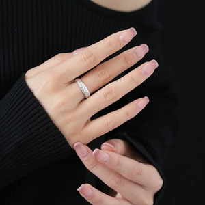 Close-up of silver zircon twisted open ring worn on finger with intricate braided texture