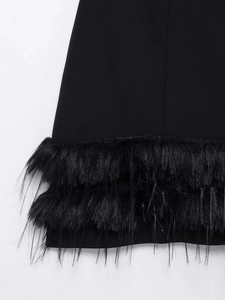 Gros plan sur les détails de plumes cousues d'une robe courte noire extensible chic