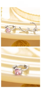 Makroansicht silberner Huggie-Ohrringe mit rosa Zirkonia-Steinen und Klickverschluss